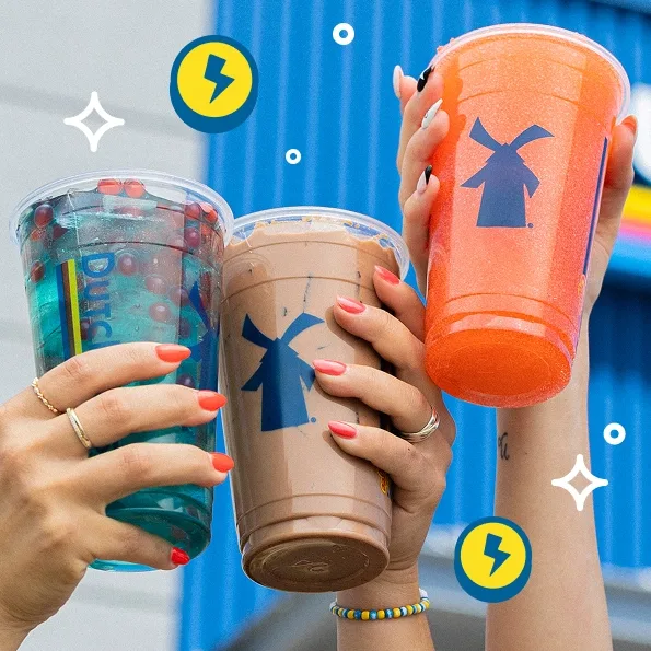 Hands with bright nail polish holding three colorful Dutch Bros coffee drinks against a blue background with graphic elements.