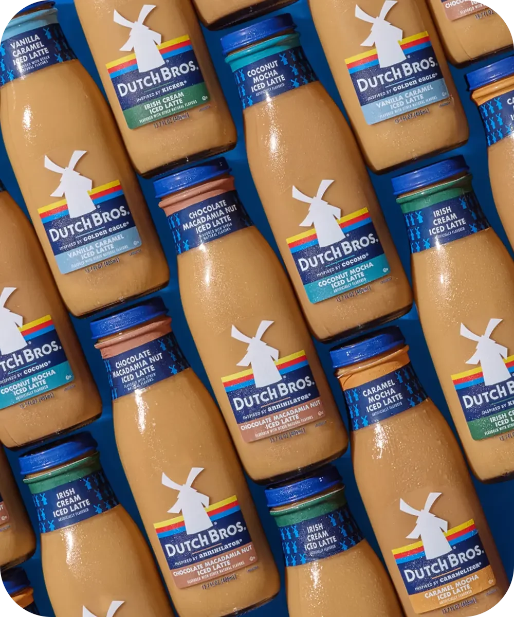 Rows of Dutch Bros bottled iced lattes in various flavors including Irish Cream, Coconut Mocha, and Vanilla Caramel.